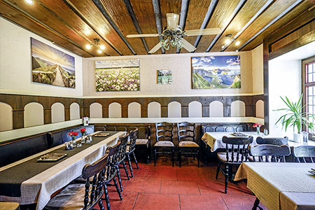 Nebenraum mit Sitzbänken und Bildern an der Wand